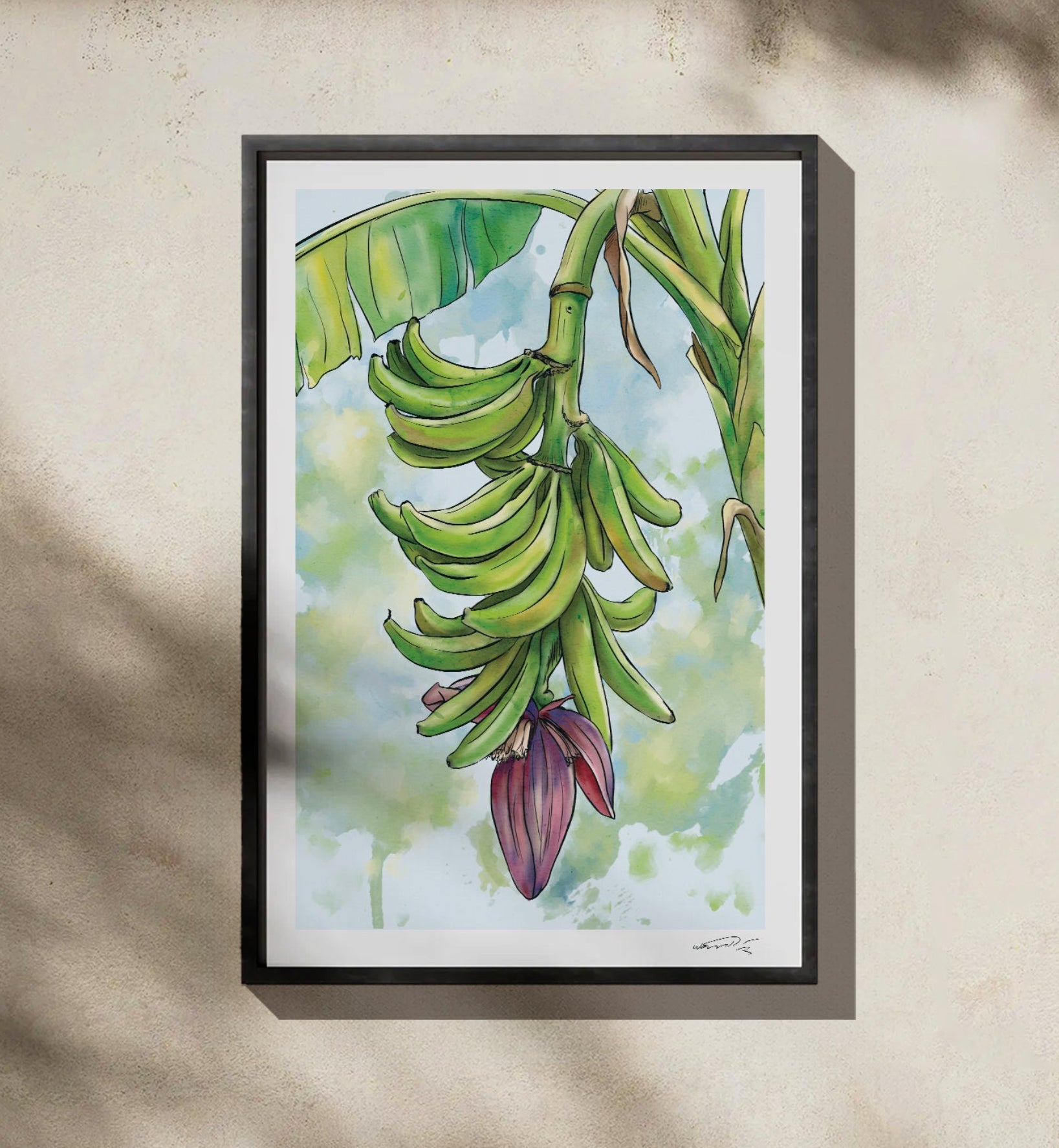 Framed artwork of a plantain plant with green plantains and leaves on a beige, concrete wall.